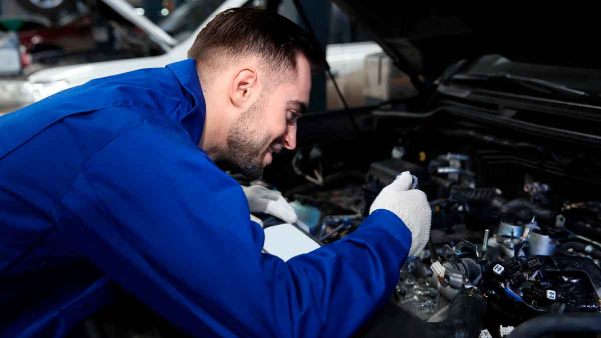 Mecánico comprobando el motor 1.0 MPI de 80 CV del Skoda Fabia Go, famoso por su fiabilidad y bajo mantenimiento