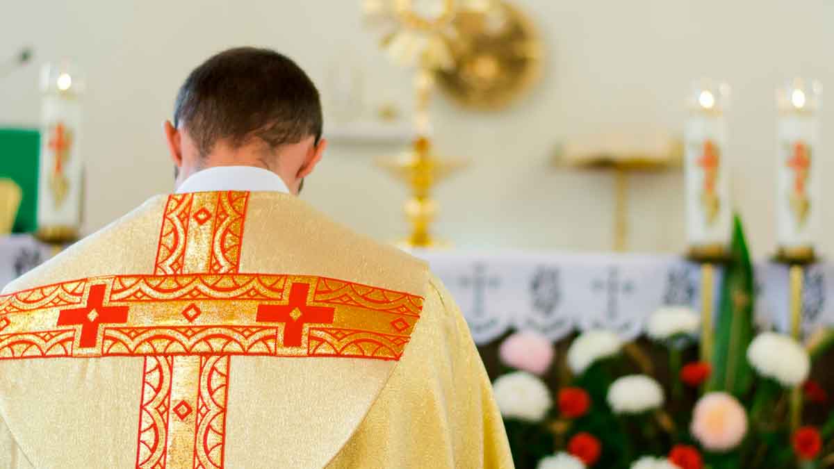 Sacerdote español de espaldas durante una ceremonia religiosa ilustrando el sueldo mensual medio que cobra un cura en España en 2025