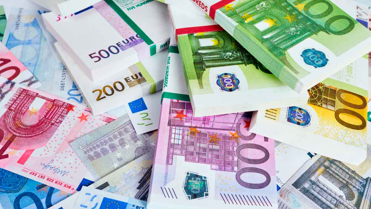Billetes de euros apilados representando sueldo necesario clase alta España 2025