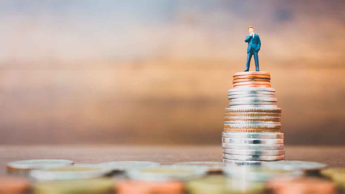 Figura de un hombre sobre una pila de monedas representando cómo los más ricos ganan 64 veces más que la media en España
