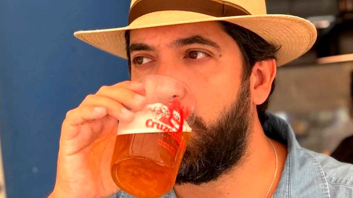 Influencer sevillano bebiendo una cerveza helada gracias al ingenioso cubo metálico con hielo de una freiduría de Huelva