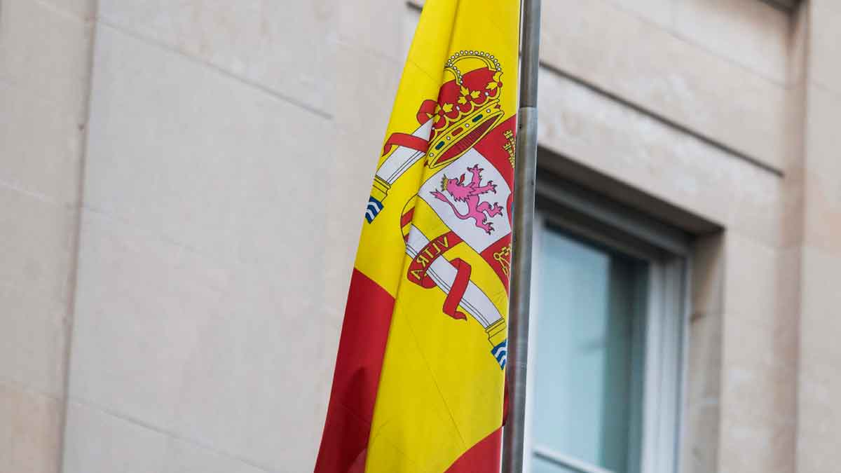 Bandera de España ondeando frente a un consulado, símbolo de la última oportunidad para solicitar la ciudadanía por la Ley de Nietos antes del 22 de octubre de 2025