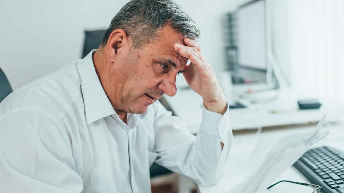 Hombre preocupado revisando documentos sobre cancelar hipoteca con la Ley de Segunda Oportunidad