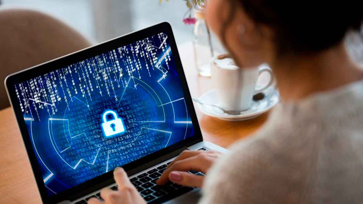 Mujer usando portátil con candado digital en pantalla como símbolo de seguridad en internet