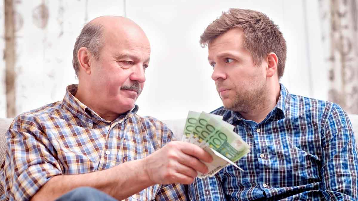Padre entregando dinero en efectivo a su hijo para comprar vivienda