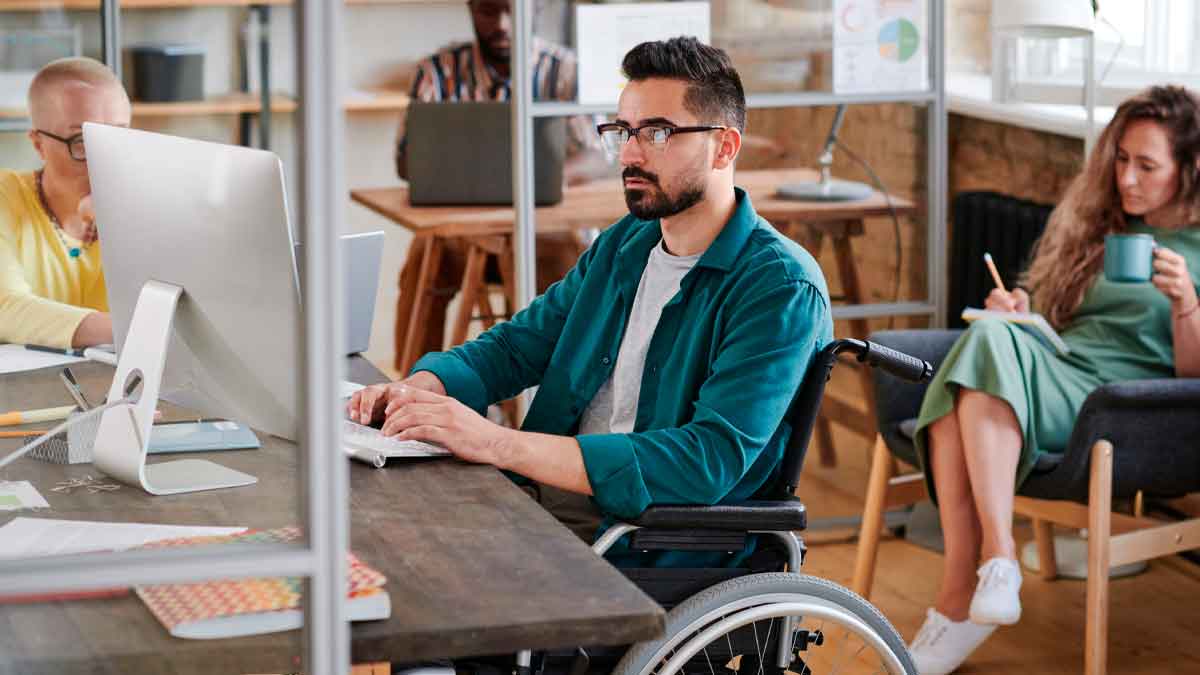 Persona con discapacidad trabajando en oficina en Andalucía con apoyo del SAE