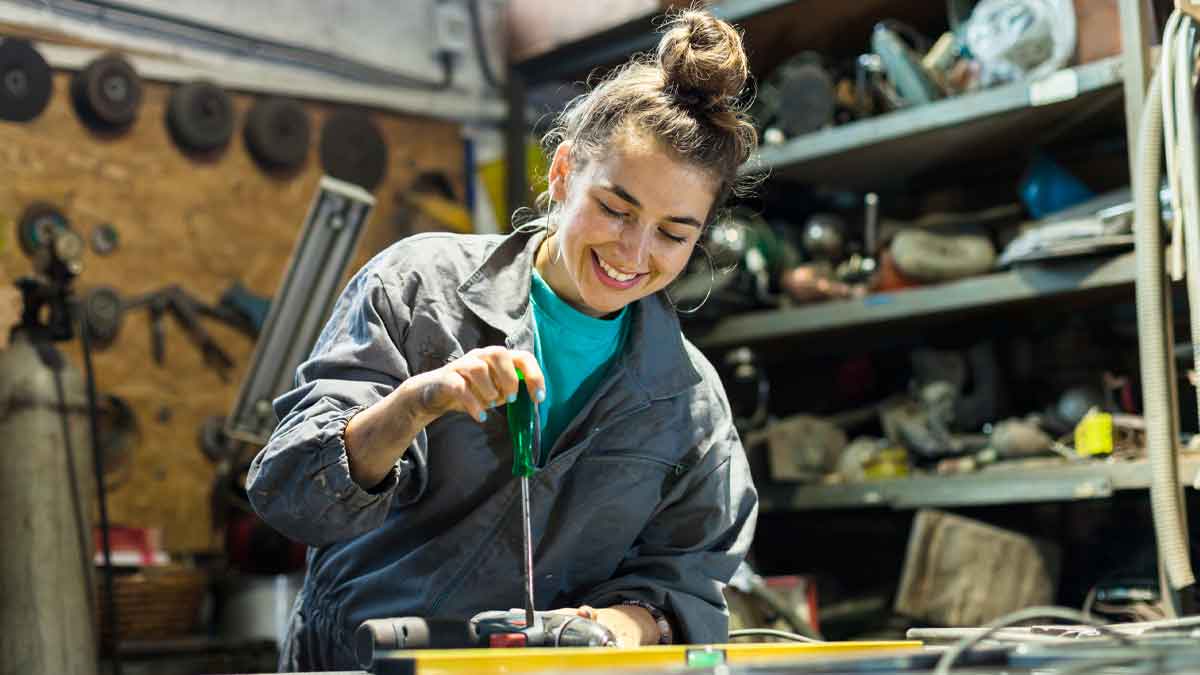 Mujer joven trabajando en taller mecánico, oferta de empleo SAE Andalucía sin oposición