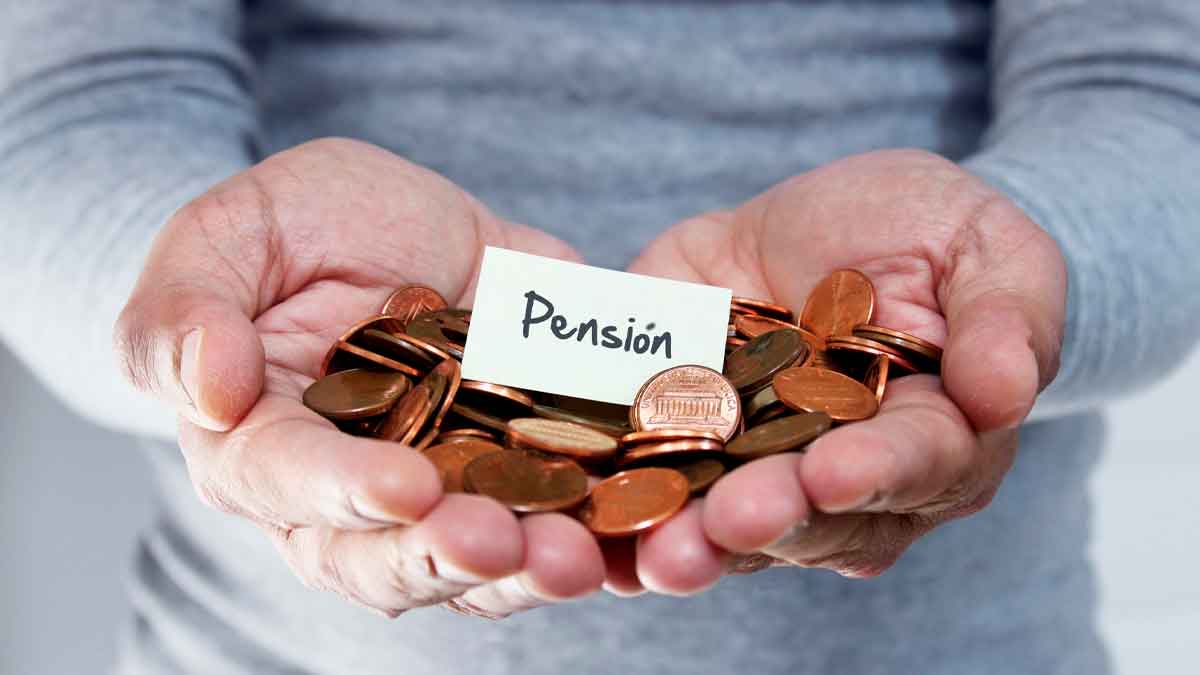 Manos con monedas y cartel de pensión compensatoria por divorcio