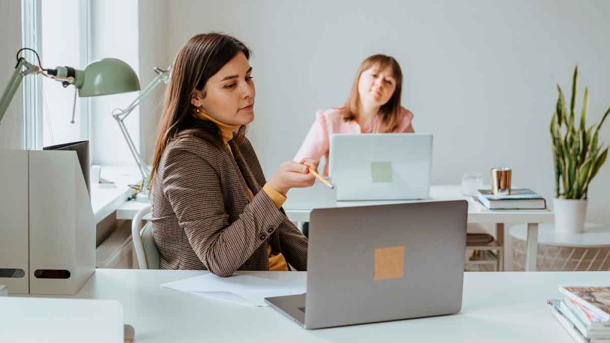 Dos mujeres emprendedoras trabajando en oficina con ordenadores portátiles en Andalucía