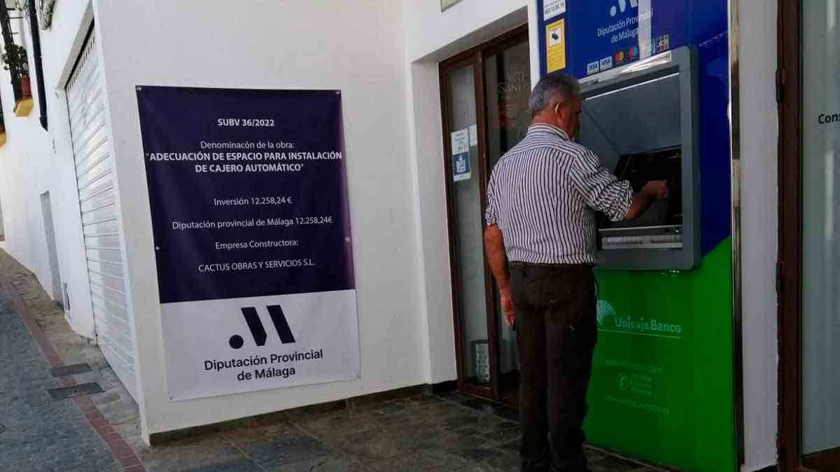 Hombre usando un cajero automático en un municipio pequeño de Málaga, en el contexto de la Ley de Accesibilidad 11/2023