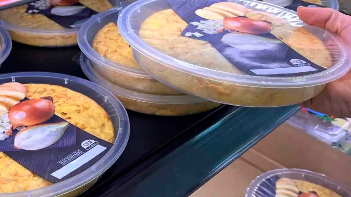 Tortilla de patata Mercadona Hacendado lista para comer en envase plástico, apilada en la estantería del supermercado