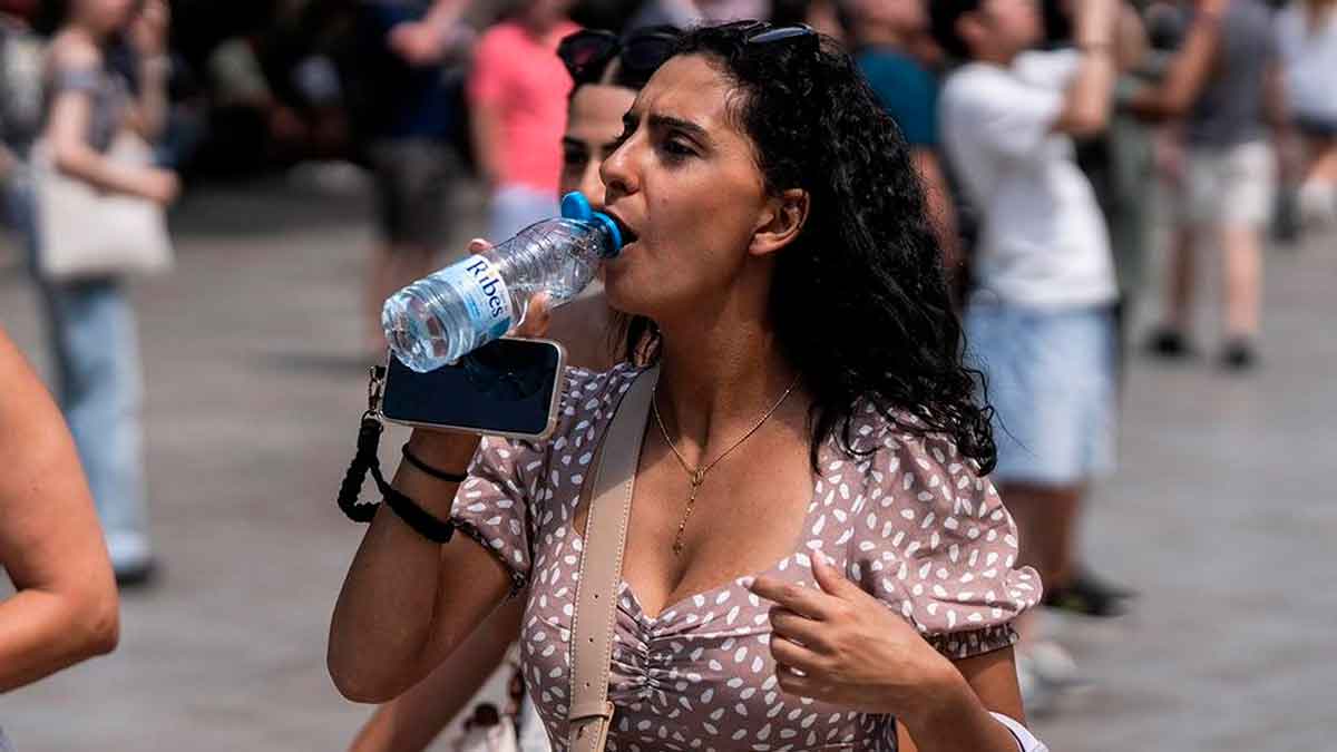 Mujer bebiendo agua para combatir la ola de calor en Andalucía con temperaturas extremas
