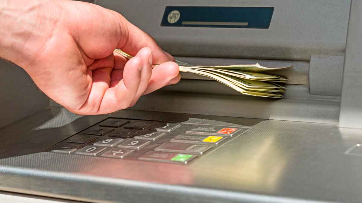 Persona retirando dinero de un cajero automático tras cobrar la pensión de agosto 2025