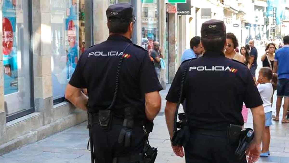 Dos agentes de la Policía Nacional patrullando por una calle en Cádiz durante investigación de estafas a mayores