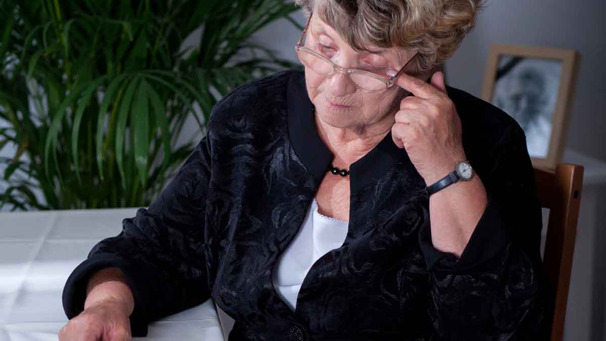 Mujer pensionista revisando documentos sobre ayudas compatibles con la pensión de viudedad