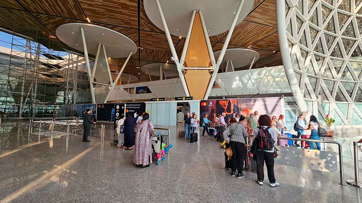 Personas con maletas en el control de un aeropuerto internacional, relacionadas con la ampliación de días para viajar cobrando el paro