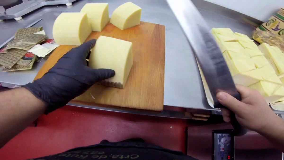 Trabajador de Carrefour cortando queso en la charcutería antes del despido