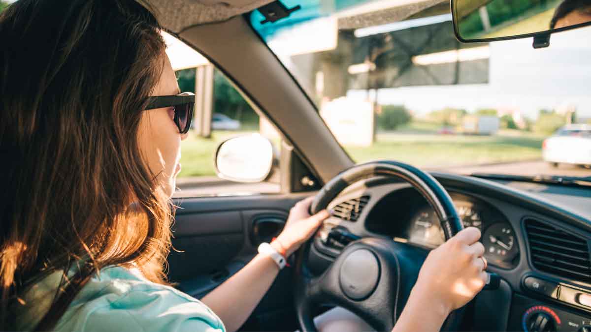 Mujer conduciendo su coche aplicando trucos del RACE para ahorrar combustible