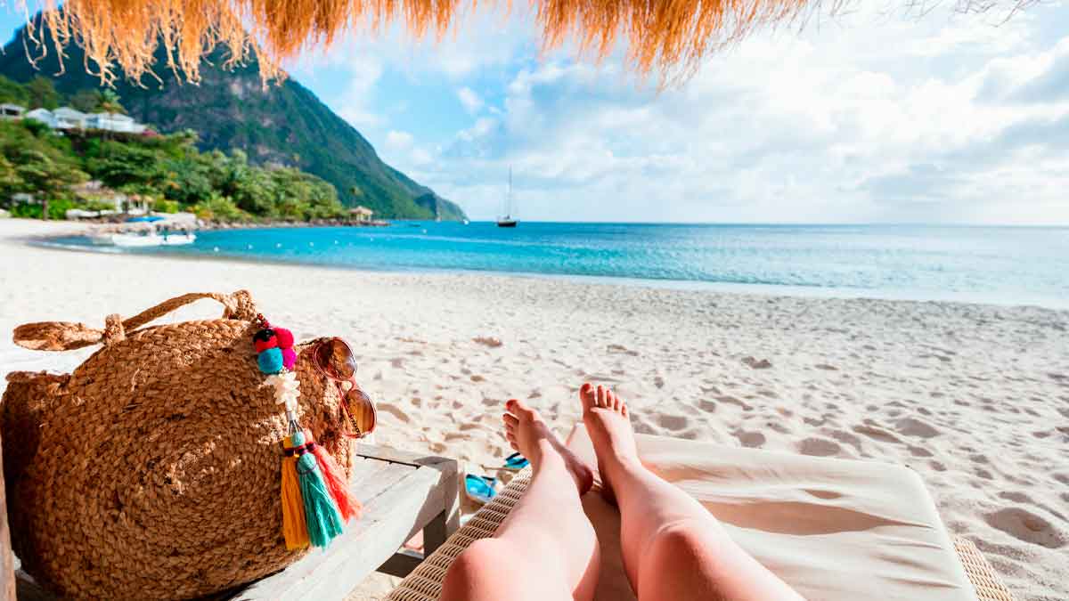 Persona descansando en la playa con bolso de paja representando vacaciones y cotización en la Seguridad Social