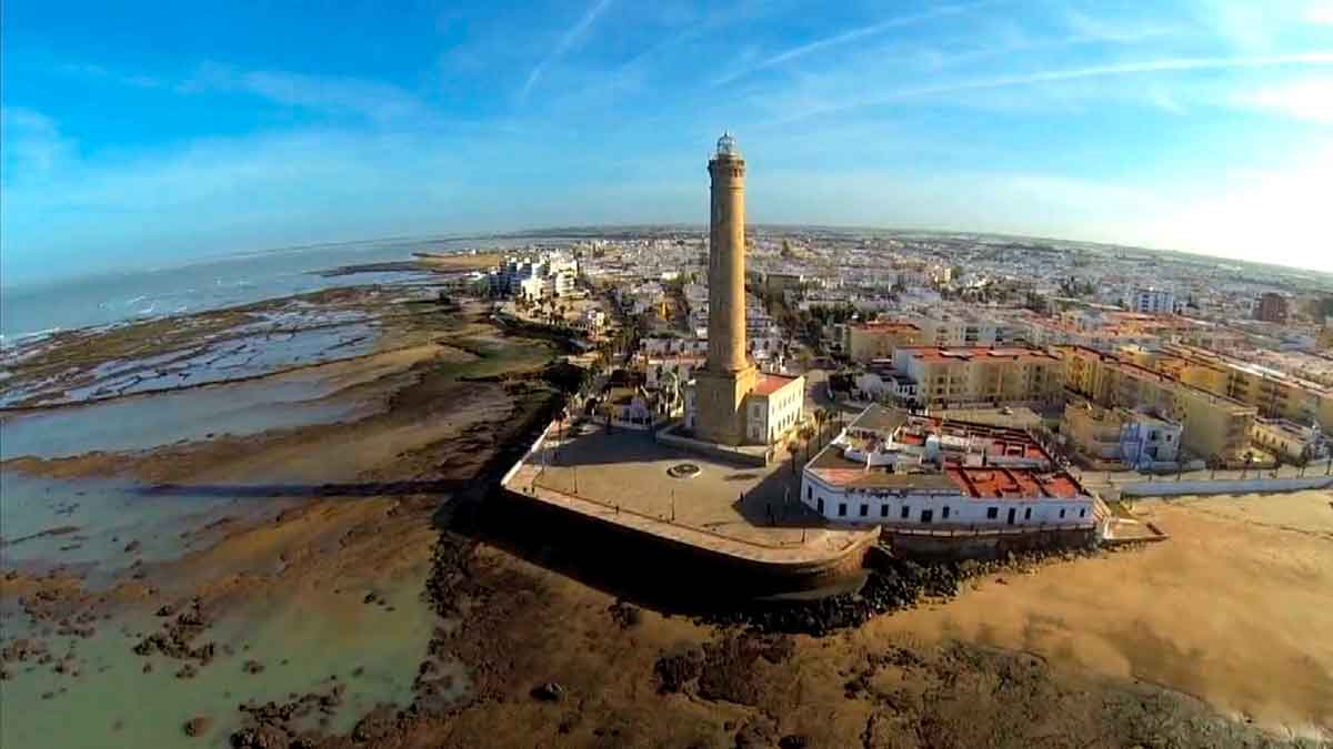 Vista aérea del faro de Chipiona, el más alto de España, junto a la costa y el casco urbano en Cádiz