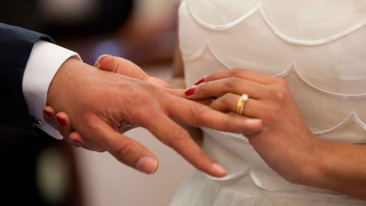 Pareja casándose intercambio de anillos permiso por matrimonio aplazamiento laboral