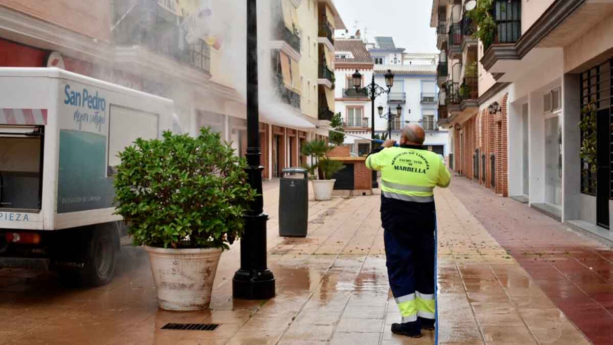 Trabajador de limpieza del Ayuntamiento de Marbella limpiando calles con agua a presión