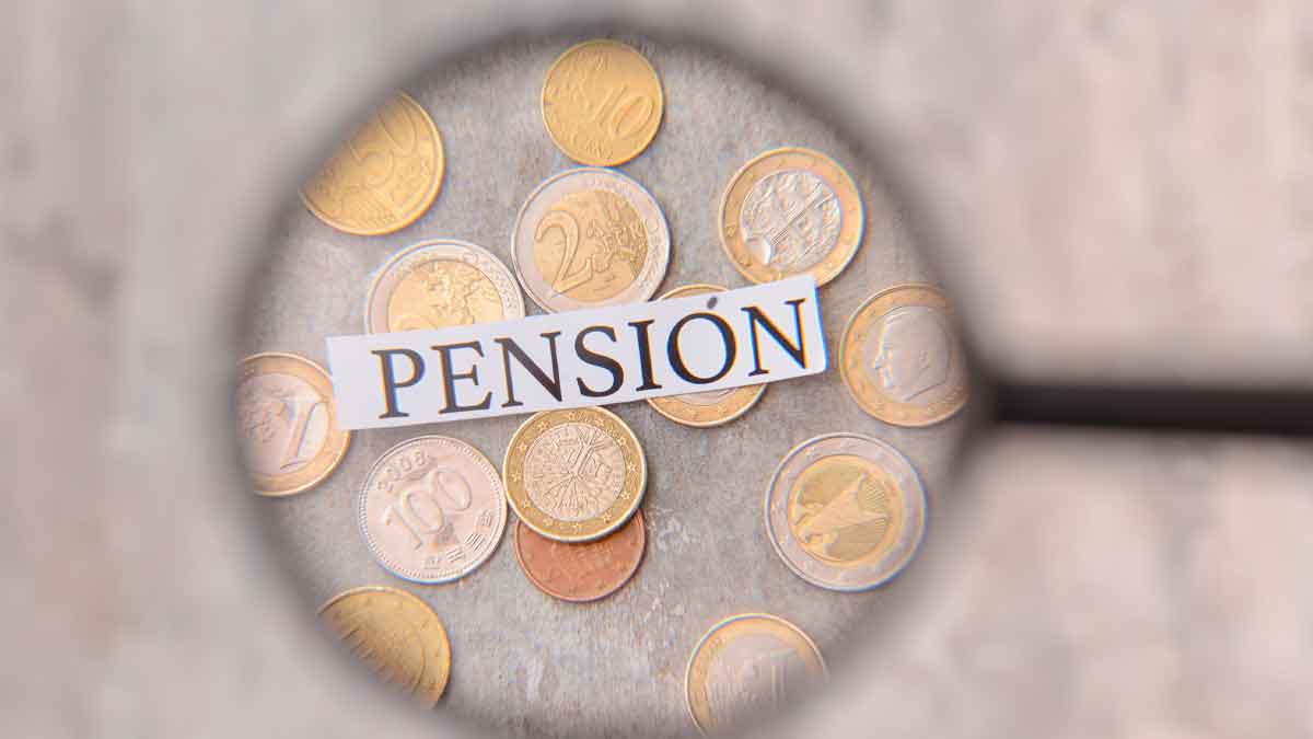 Monedas de euro con la palabra pensión destacada con lupa