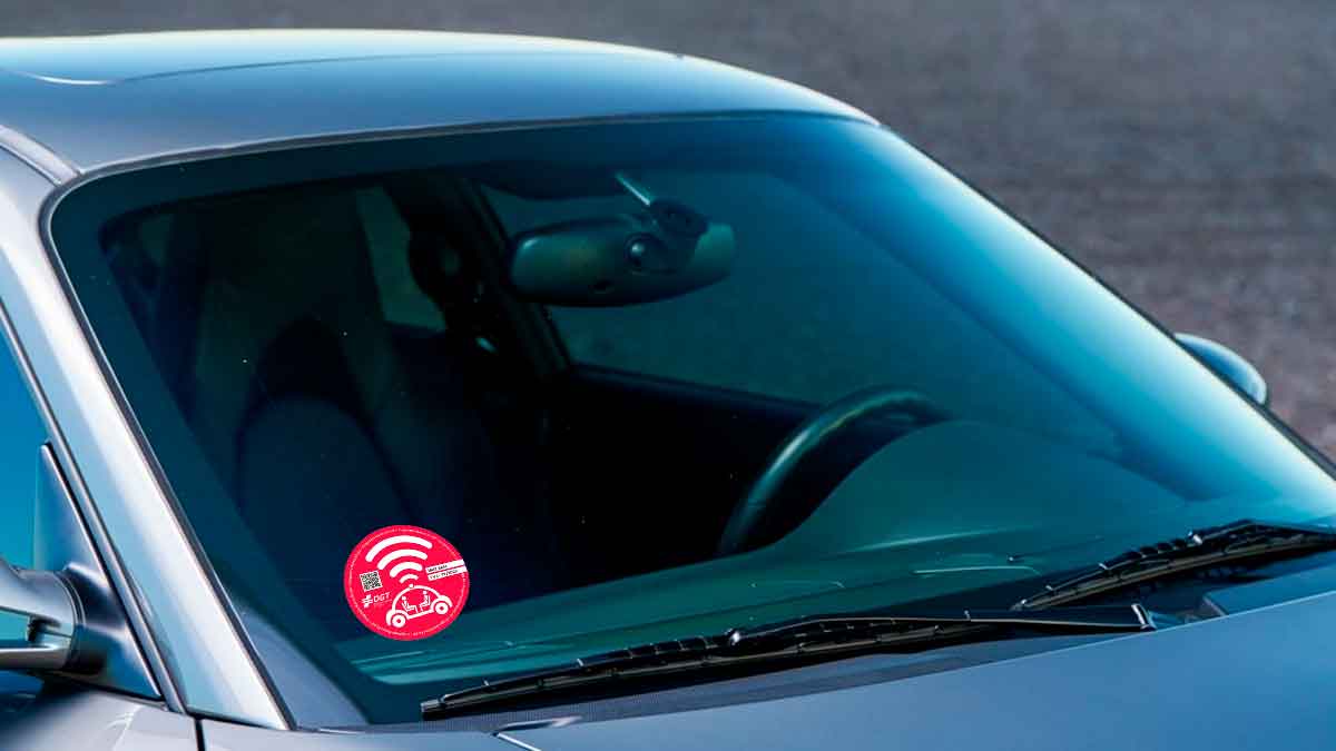 Pegatina rosa de la DGT en el parabrisas para identificar vehículos autónomos autorizados en España
