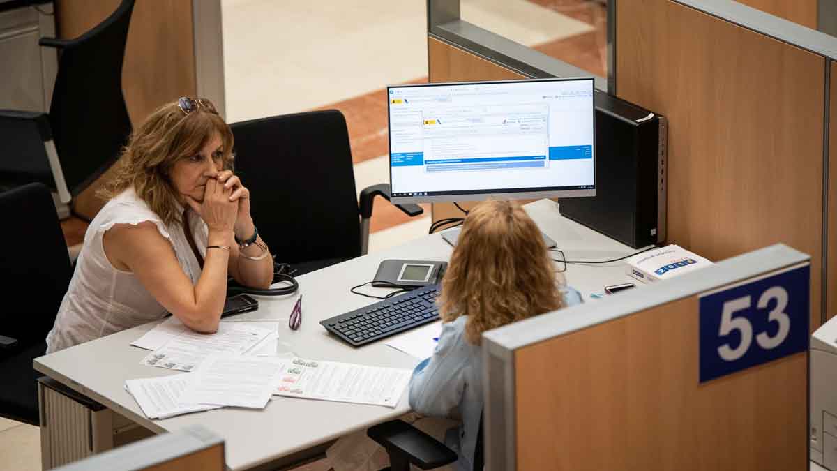 Mujer entregando documentación del ingreso mínimo vital en oficina de la Seguridad Social