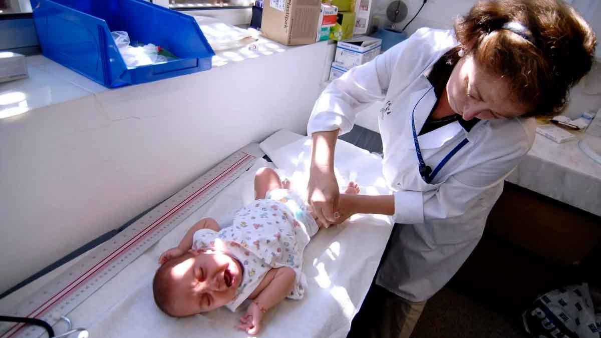 Profesional sanitario revisa a un bebé en consulta dentro del Programa de Salud Infantil de Andalucía