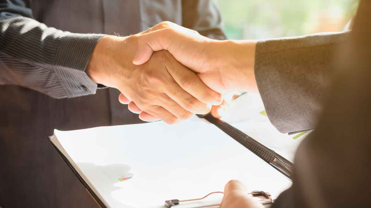 Dos personas estrechando manos tras acuerdo para cancelar deudas con la Ley de Segunda Oportunidad