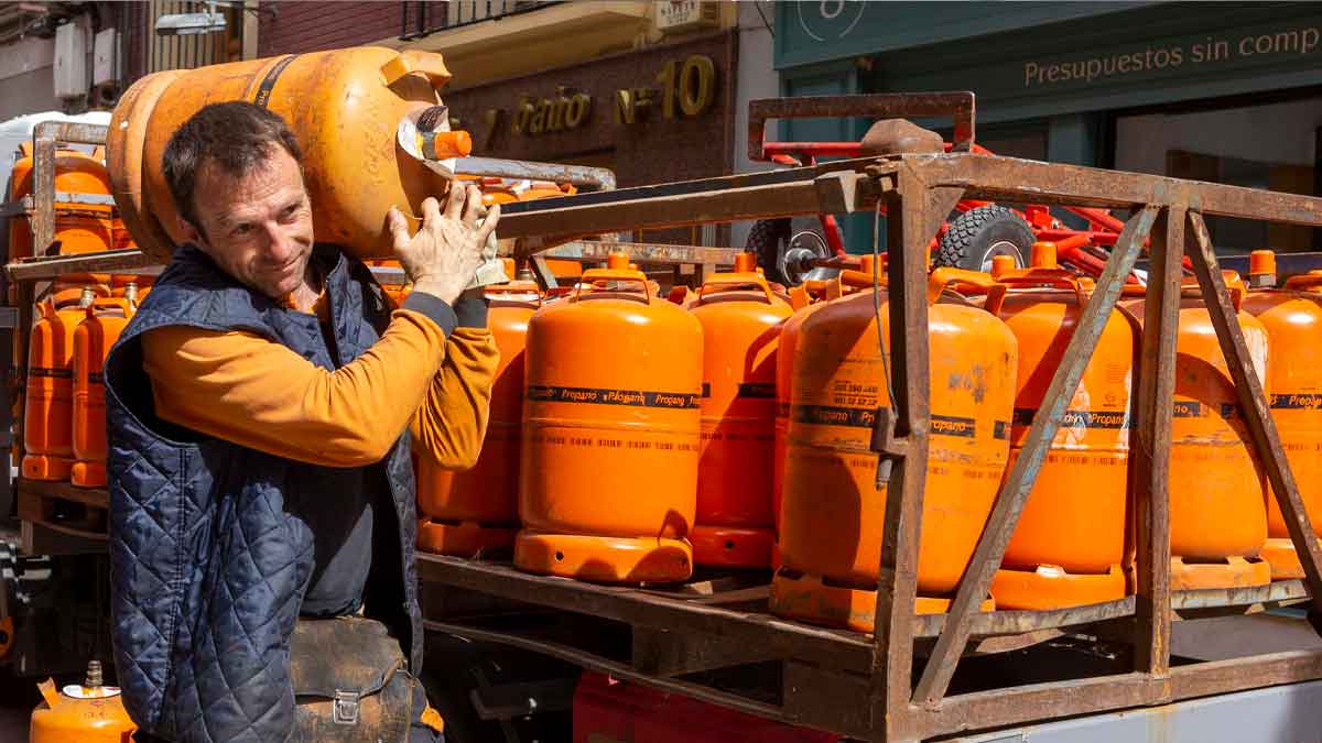 Repartidor cargando bombona de butano tras la bajada de precio oficial del BOE