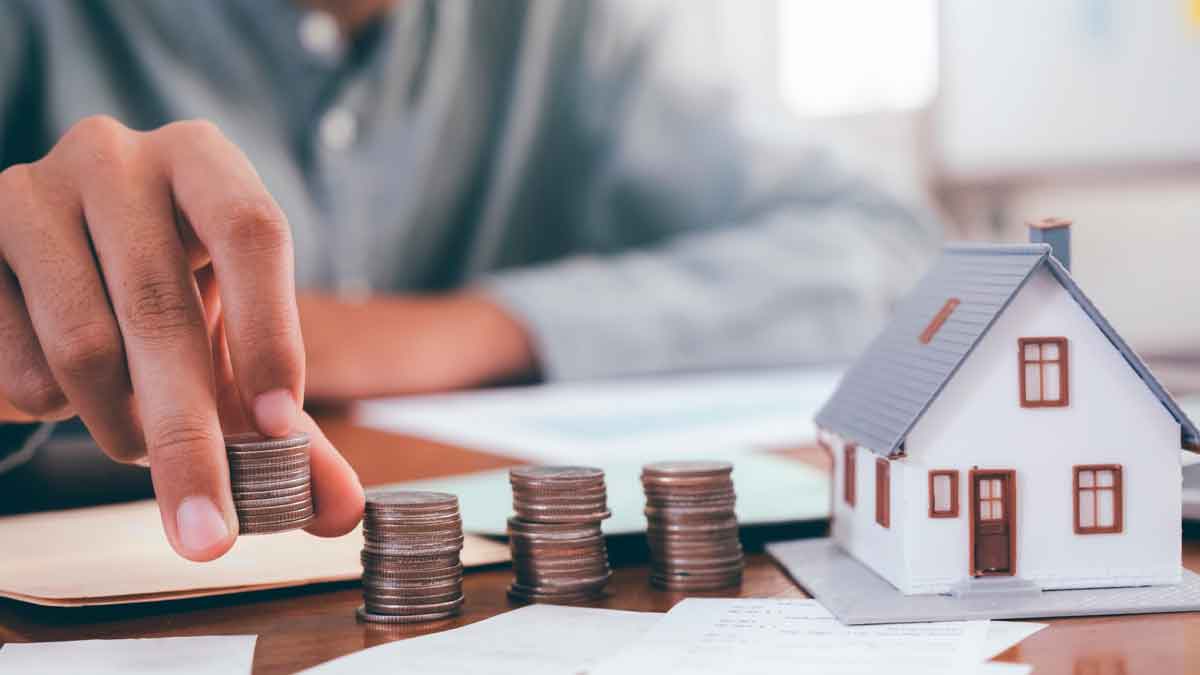 Persona contando monedas junto a una casa en miniatura representando la reclamación de gastos de hipoteca en 2025