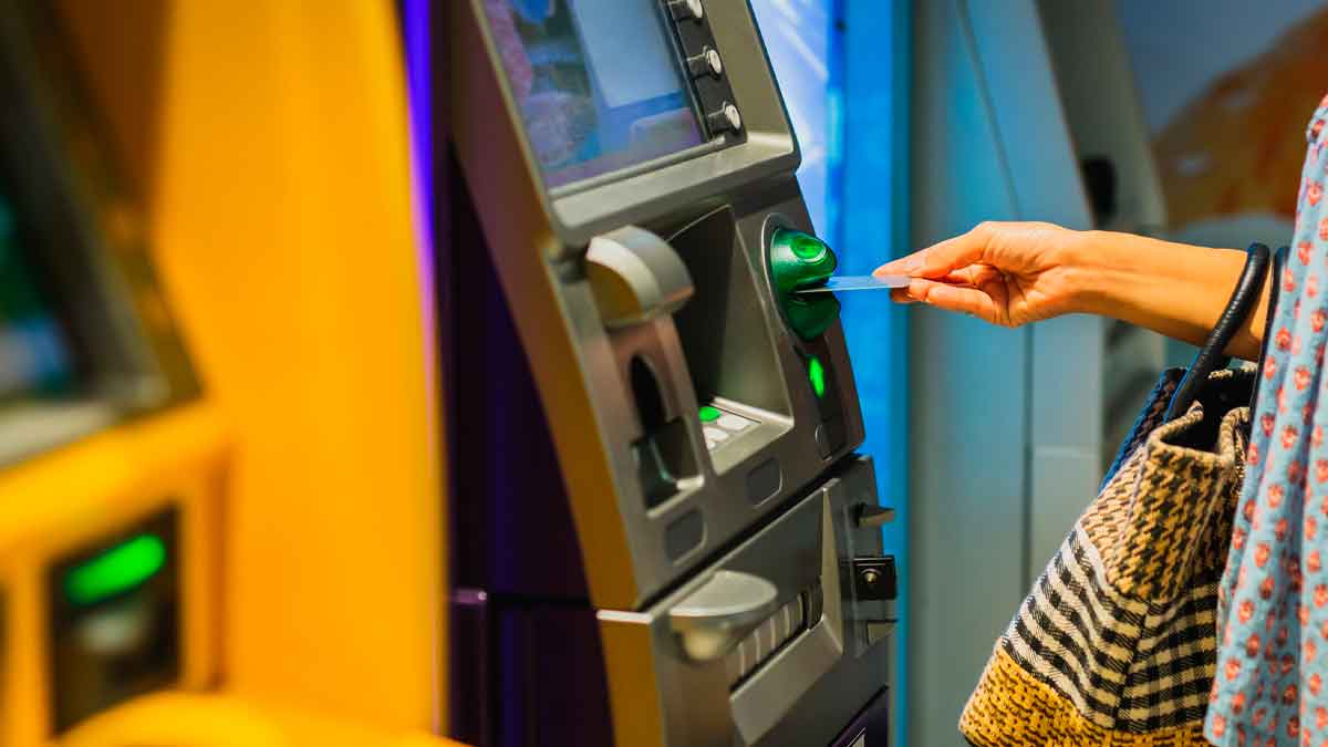 Persona sacando dinero en un cajero automático sin pagar comisiones