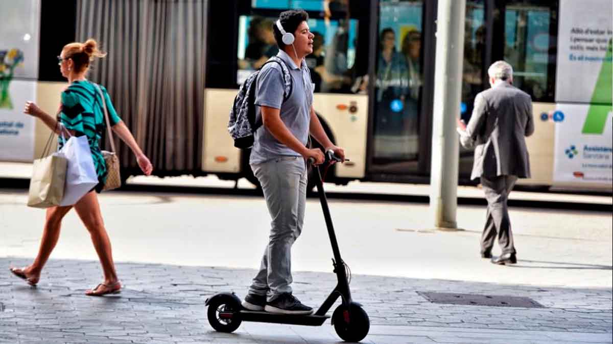 Joven circulando en patinete eléctrico en la calle con seguro obligatorio