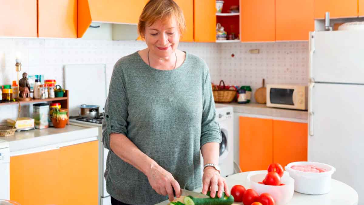 Mujer preparando comida en casa, símbolo de las amas de casa que podrán cobrar la pensión del IMSERSO de 564 euros