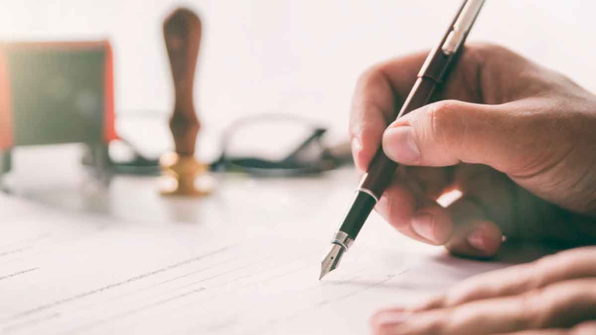 Persona firmando documentos de herencia en Andalucía con rebajas del 99 por ciento en el impuesto de sucesiones y donaciones