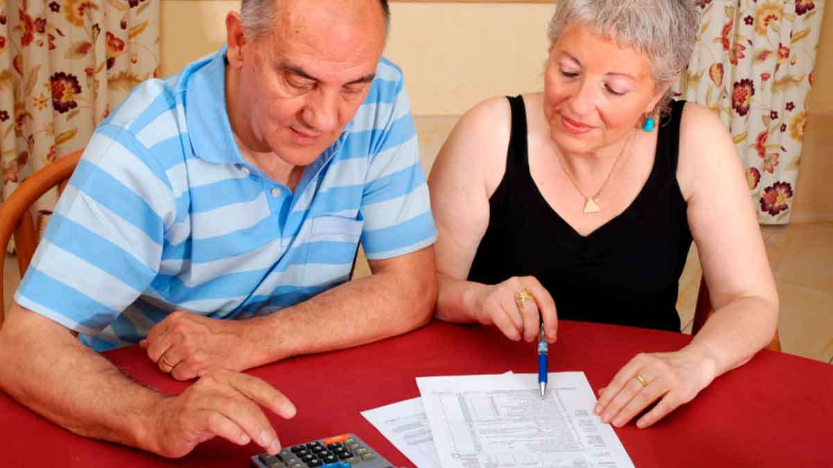 Pareja de jubilados revisando sus ahorros y planes de pensión en casa