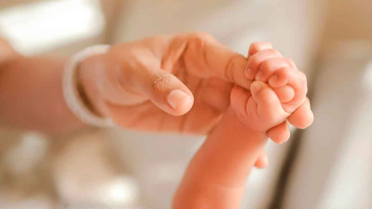 Mano de madre sosteniendo la mano de un bebé, imagen sobre la ayuda de 1.000 euros por nacimiento o adopción de la Seguridad Social