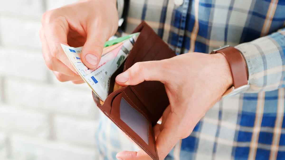 Persona sacando dinero de la cartera representando las ayudas sociales de Montemayor para alimentación, vivienda y natalidad 2025