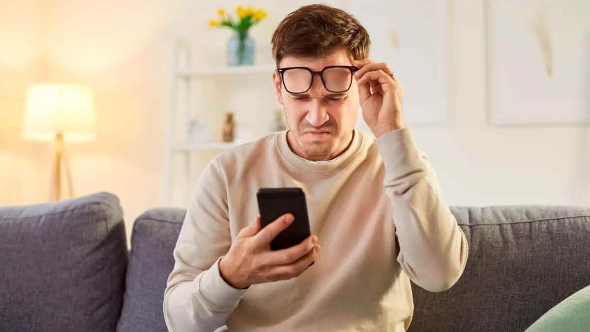 Hombre preocupado revisando su móvil tras recibir una alerta del Banco de España sobre estafas en alquileres pagados por transferencia