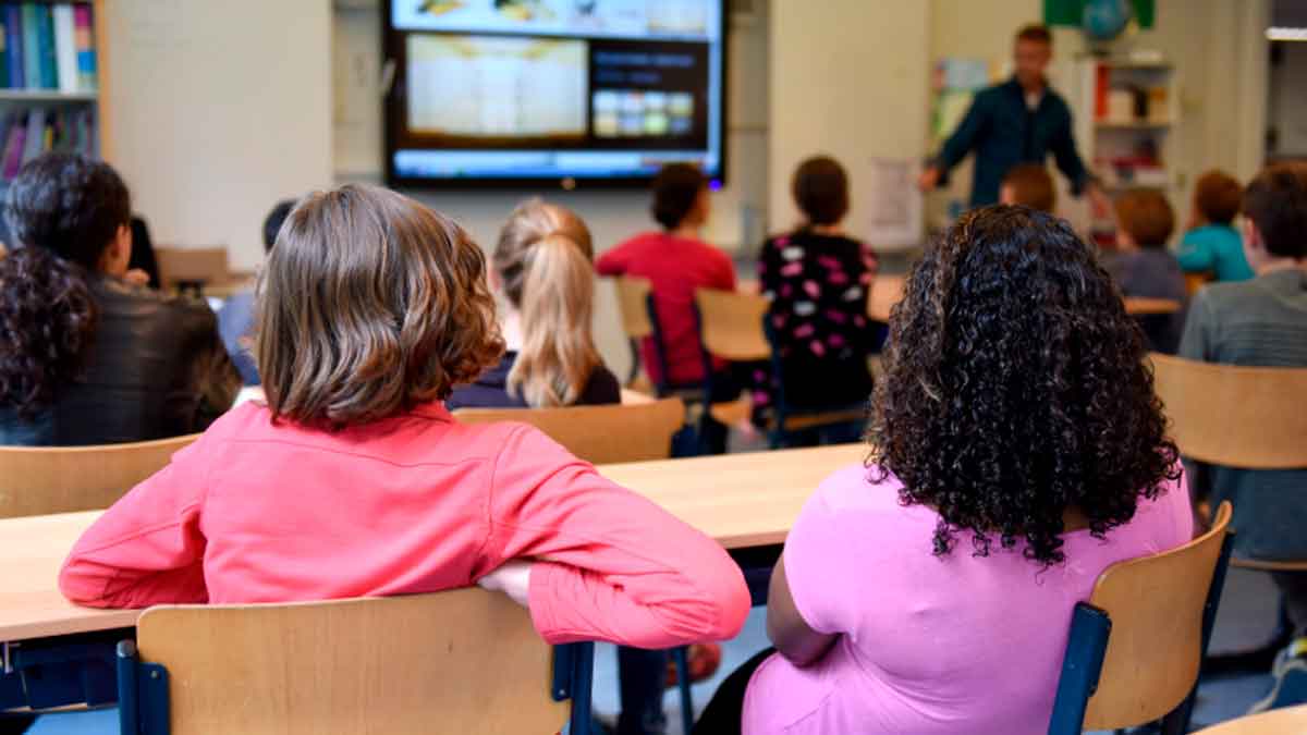 Niños en clase durante el curso escolar representando la nueva beca de 125 euros para material escolar 2025 2026