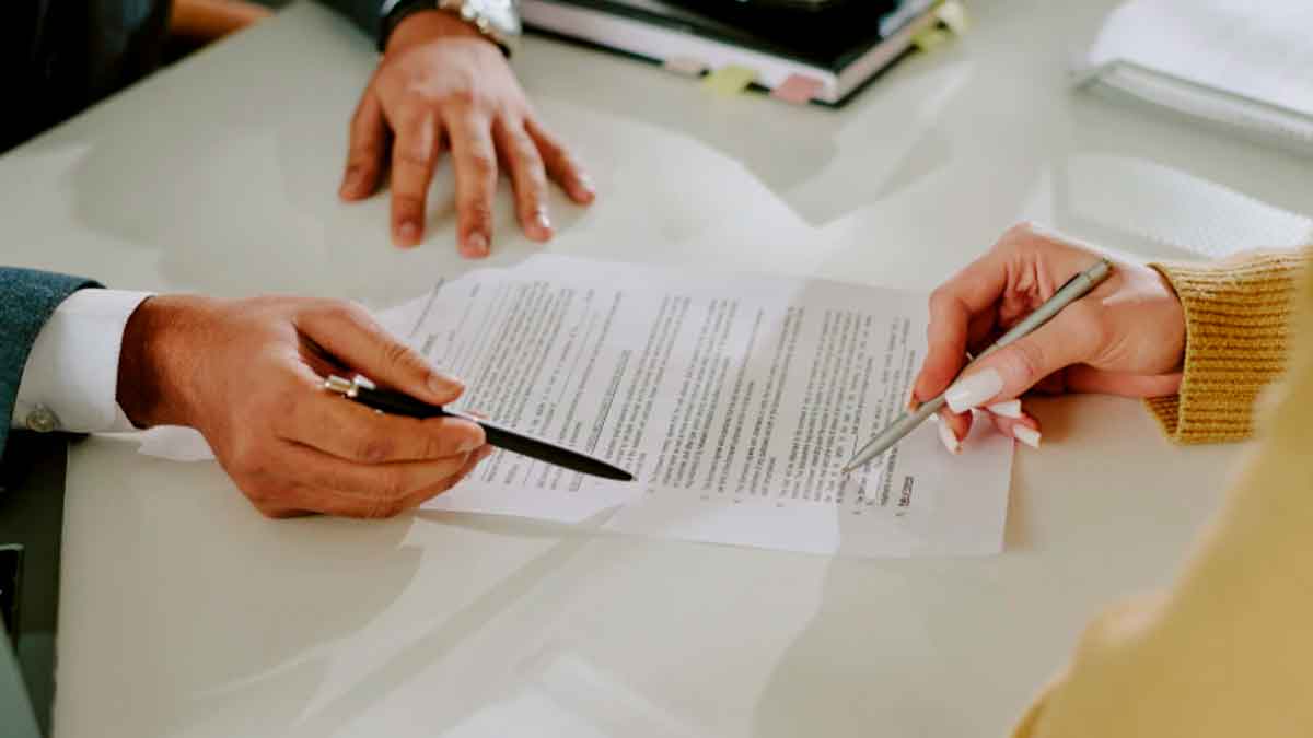 Personas revisando y firmando documentación para comprobar si son beneficiarios de un seguro de vida por fallecimiento