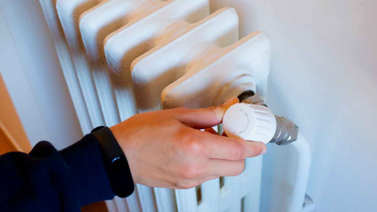 Persona ajustando la calefacción en casa para ilustrar el Bono Social Térmico que ayuda a pagar los gastos energéticos
