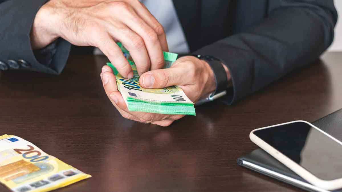 Persona contando billetes de euro en una oficina del Banco de España para realizar un cambio gratuito de efectivo