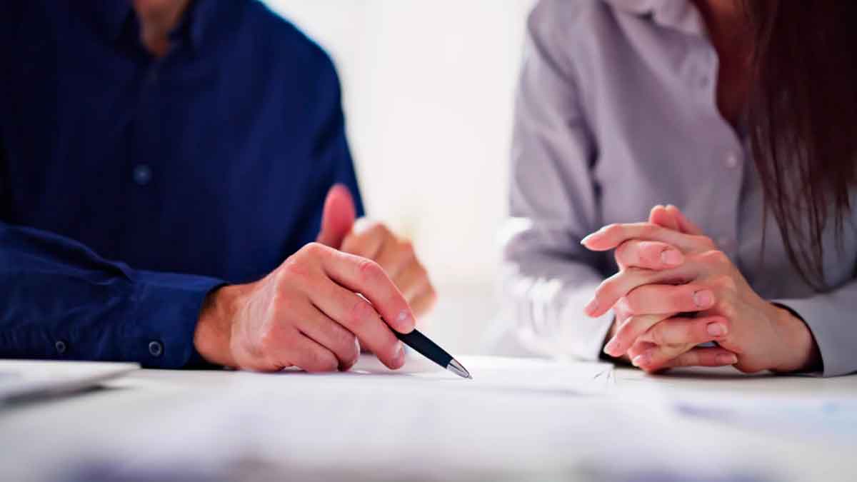 Personas revisando un contrato bancario para ejercer el derecho de desistimiento sin penalización