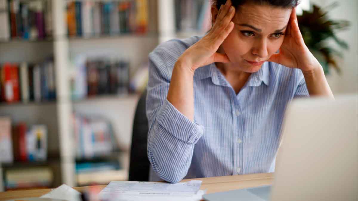 Trabajadora preocupada frente al ordenador tras ser despedida por el chatbot que entrenó durante años en el banco