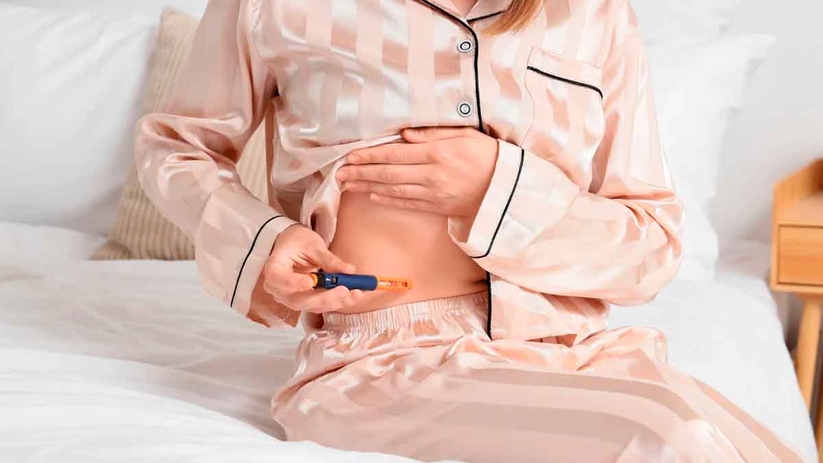 Mujer aplicándose una inyección en el abdomen como parte de un tratamiento de fertilidad