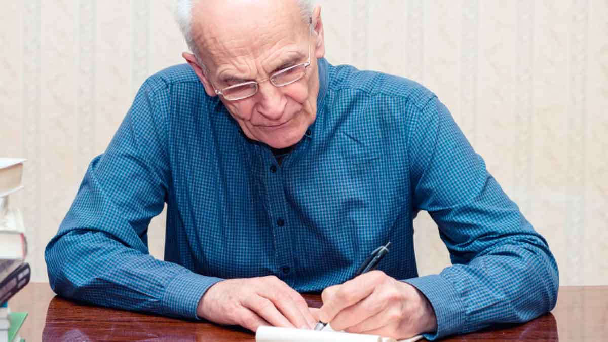 Hombre mayor rellenando formularios para solicitar la devolución del IRPF como mutualista ante Hacienda