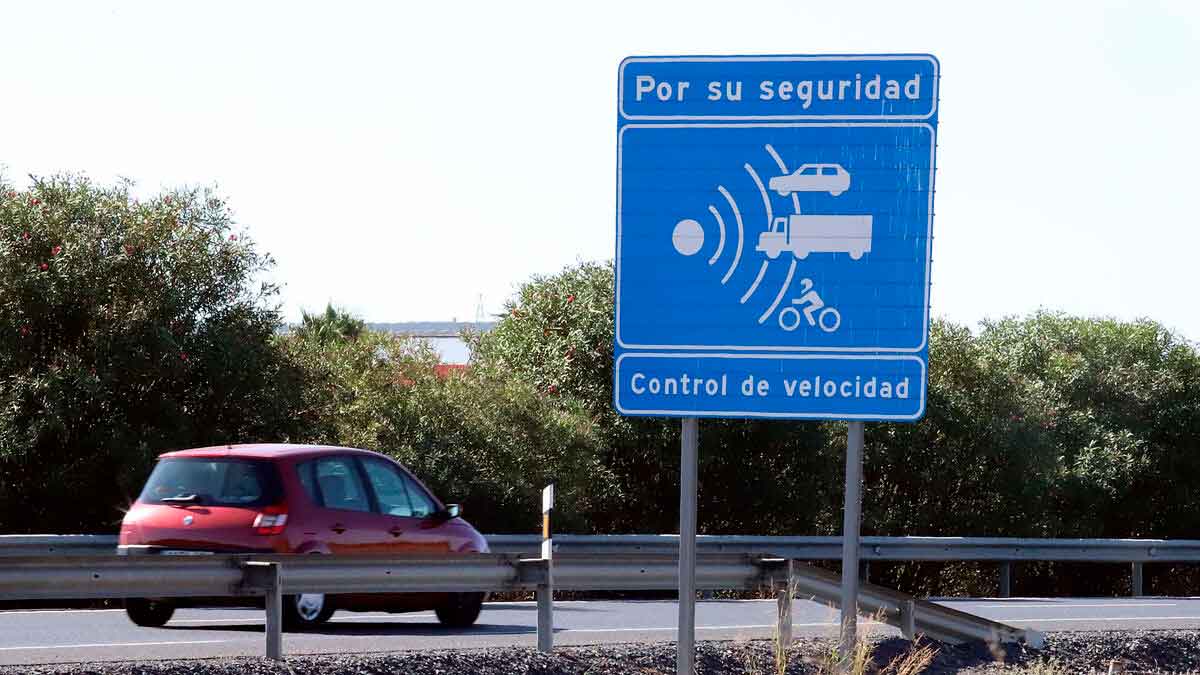 Señal de control de velocidad de la DGT en una carretera de Andalucía con un coche circulando